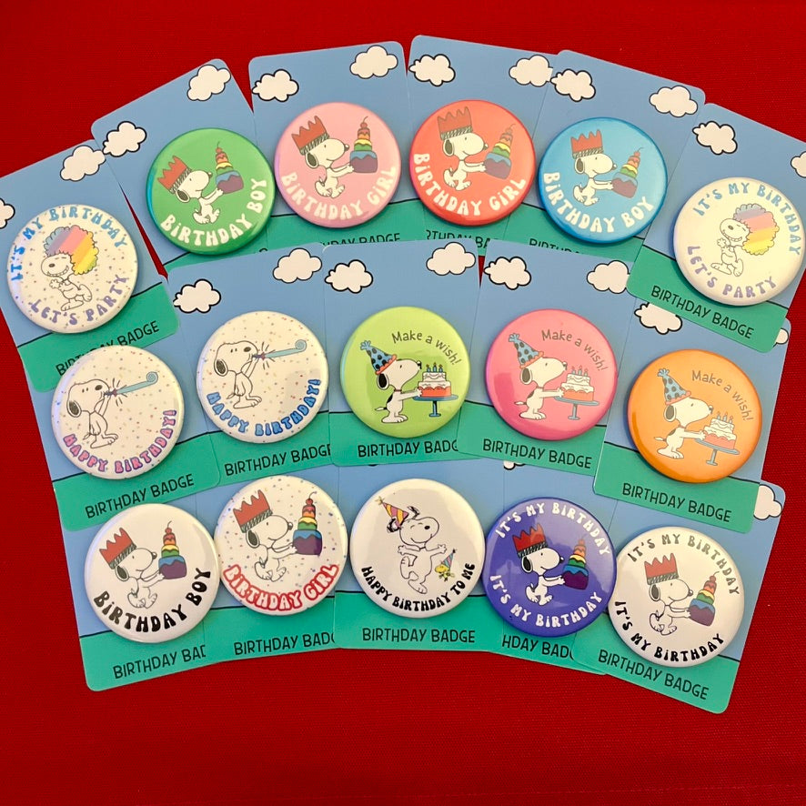 Collection of Snoopy retro themed birthday pin badge on a display card with a red background