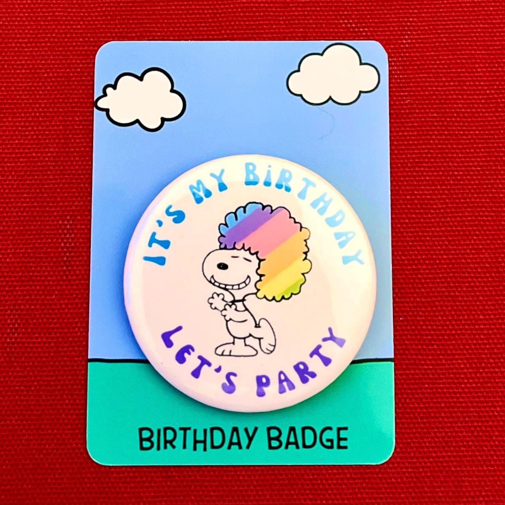 Birthday badge with cartoon character Snoopy and 'It's my birthday, let's party' text on a red background